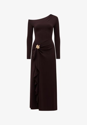 Asimetriška ilgos rankovės juoda suknelė su viena petneša, šoniniais raukiniais ir dekoratyvine auksine gėlių sagė juosmens srityje.