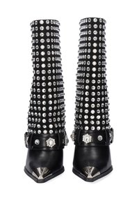 Botas altas negras con adornos de tachuelas plateadas, con puntera puntiaguda, acentos metálicos y una correa ancha decorada con una gema.
