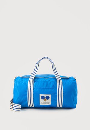 Lyseblå duffel taske med hvide og blå stribede håndtag og skulderrem, der har et frontpatch med krydsede bordtennisbat.