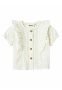 Blusa blanca de manga corta con volante en el frente, cinco botones de madera, tela texturizada con rayas verticales y escote redondo.