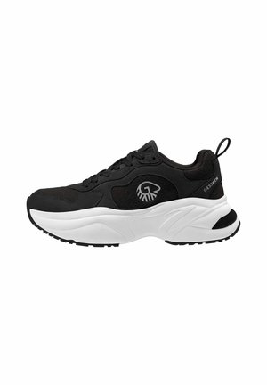 Black athletic shoe with a textured upper, white midsole, rubber outsole, and logo detail on the side and heel. Laced design with rear pull tab.