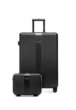 Dwie czarne walizki z twardą skorupą o teksturowanych pionowych liniach, jedna duża z chowanym uchwytem i czterema kółkami, druga mniejsza bez widocznych uchwytów.