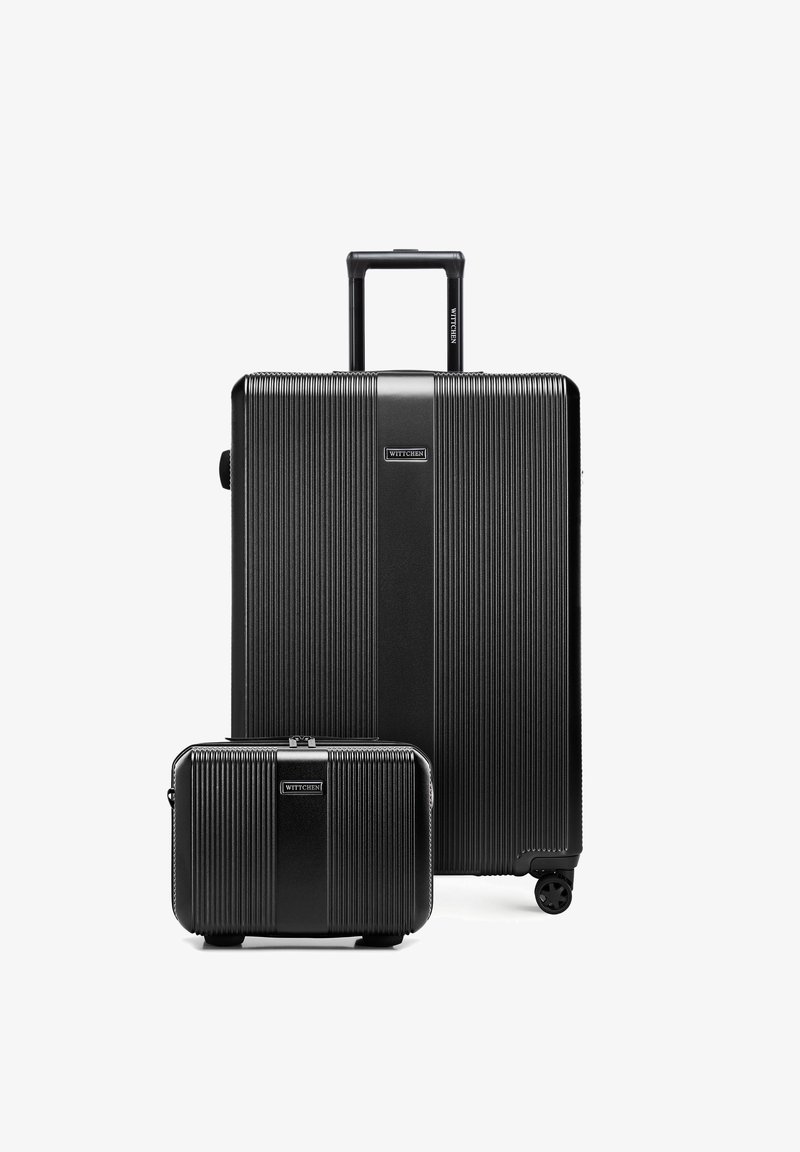 Two black hard-shell suitcases with textured vertical lines, one large with a retractable handle and four wheels, one smaller without visible handles.