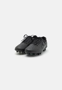 Sorte fodboldstøvler med en struktureret syntetisk overdel, flade snørebånd og en formstøbt sål med studs; strømlinet design med en reflekterende sølvaccent.