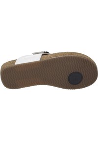 White cork-bottom sandal featuring a textured rubber outsole with a herringbone pattern, adjustable strap, and branded hardware detail.