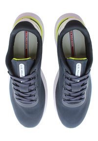 Ciemnoniebieskie buty sportowe z siateczkową cholewką, okrągłym noskiem, sześcioma oczkami i białą podeszwą środkową. Posiada neonowozielone akcenty na pięcie.