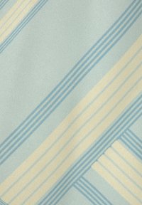 Svetloblaga tkanina z diagonalnimi črtami v svetlo rumeni in temnejši modri barvi. Gladka tekstura z rahlim leskom.