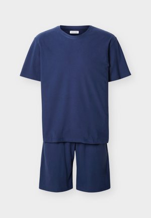 Conjunto de camiseta de manga corta con cuello redondo en azul marino y pantalones cortos a juego hasta la rodilla con un ajuste relajado, sobre un fondo blanco.