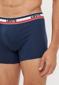 Μαύρες μπλε μποξέρ με μαλακή υφή, διαθέτουν λευκή, κόκκινη και μπλε ελαστική ζώνη με το λογότυπο "Levi's".