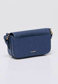 Borsa a tracolla in pelle blu navy con pannello frontale testurizzato, hardware dorato e tracolla regolabile, marchiata con piccole lettere dorate.