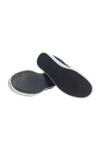 Granatowe loafersy z białymi gumowymi podeszwami, posiadające teksturowaną spódnię dla lepszej przyczepności oraz prosty design z dwoma poziomymi paskami.