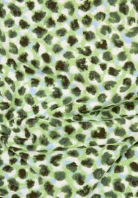 Grüner Stoff mit einer weichen Textur, der ein unregelmäßiges Leopardenmuster in Dunkelbraun und hellblauen Akzenten aufweist.