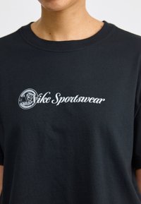 Juodas medvilninis marškinėlis su balta „Vice Sportswear“ užrašą ir logotipą, išsiuvinėtą ant priekio, su klasikiniu apvaliu kaklu ir trumpomis rankovėmis.