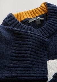 Maglione blu navy con colletto a coste color senape, caratterizzato da sezioni textured e un corpo liscio. L'etichetta riporta "NEXT."