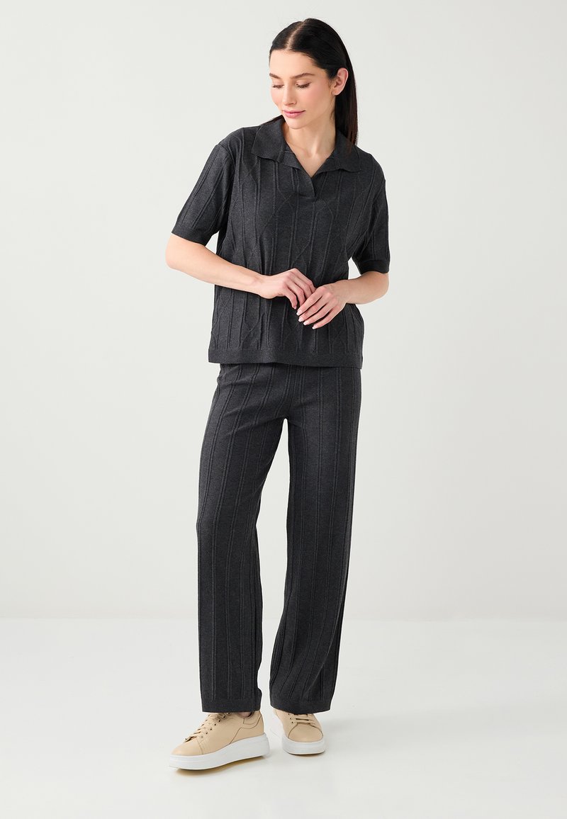 Haut tricoté gris foncé à manches courtes avec col, accompagné d'un pantalon large assorti. Présente des rayures verticales côtelées et une texture douce.
