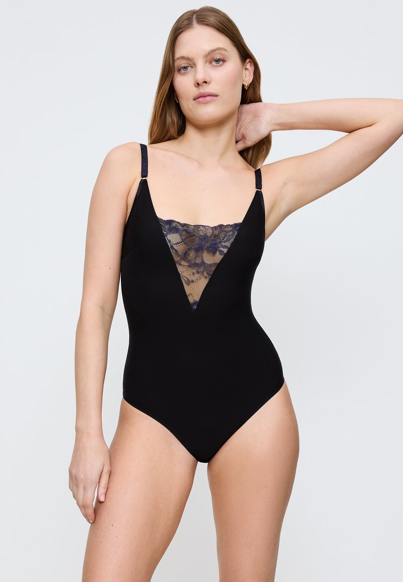Czarny jednoczęściowy strój kąpielowy z głębokim dekoltem w serek, ozdobiony przezroczystymi koronkowymi detalami na klatce piersiowej oraz regulowanymi ramiączkami dla idealnego dopasowania.