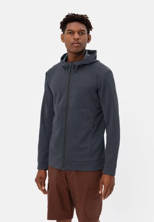 Giacca con cappuccio zip-up grigio scuro in tessuto testurizzato, con tasche laterali e una vestibilità aderente. Abbinata a pantaloni corti marroni per un look casual.