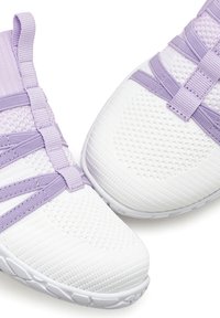 White athletic shoes with lavender accents, featuring a mesh upper, textured surface, and elastic strap design for secure fit.