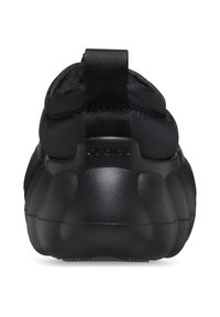 Zwarte Crocs-schoenen met een gevoerde bovenkant, textuurrubber zool en een trekhaak aan de achterkant voor gemakkelijke aan- en uittrekking. Ronde, stevige vorm.