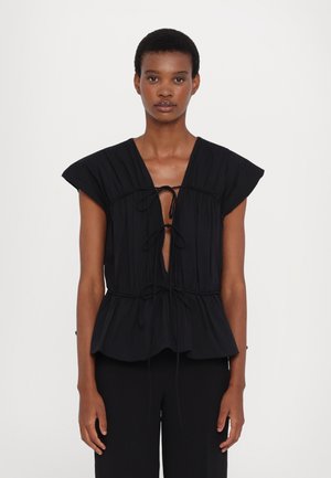 Zwarte blouse met een diepe V-hals en een gathered taille. Heeft korte mouwen en een decoratieve striksluiting aan de voorkant, gemaakt van zachte stof.