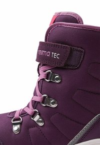 Bottine montante violette en tissu texturé, ornée de lacets roses, de crochets en métal et d'une sangle Velcro avec le logo "reima TEC".