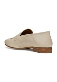 Mocacines de cuero beige con un bajo tacón apilado en marrón, con un diseño de punta plana y costuras visibles a lo largo de los bordes.