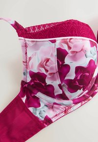 Sutien cu model floral mov pal, cu margine superioară dantelată, bandă spate solidă și cusături detaliate. Prezintă un finisaj neted, asemănător satinului.