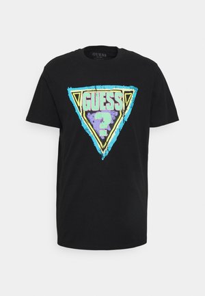 Sort t-shirt med korte ærmer og et slidt trekantet grafik i turkis, gul og lilla med ordet "GUESS" og et spørgsmålstegn.