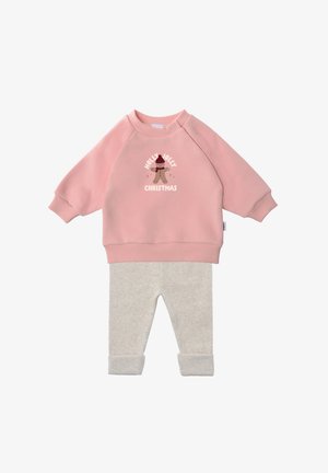 Rosa Fleece-Sweatshirt mit einem "Holly Jolly Christmas"-Grafikdruck, kombiniert mit hellgrauen, gerippten Hosen mit umgeschlagenen Bündchen.