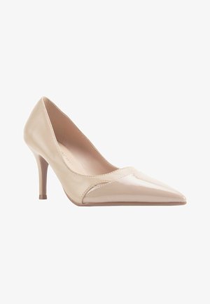 Escarpin en cuir verni beige avec un bout pointu et un talon stiletto fin. Texture lisse avec des détails de couture subtils.