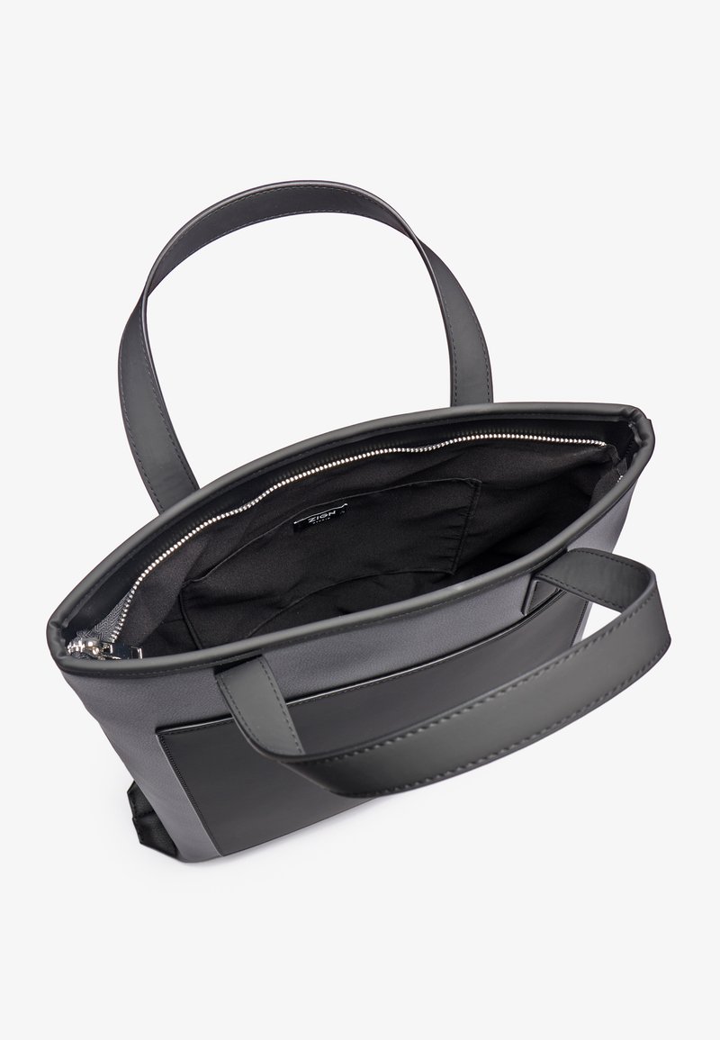 Sac fourre-tout en cuir noir avec fermeture éclair, extérieur lisse, deux poignées plates et un intérieur spacieux doublé en tissu.