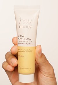 Maschera di bellezza a base di oro colloidale e miele in un tubo beige chiaro con tappo bianco. Il testo include il nome del prodotto e i benefici. Dimensione 60 ml.