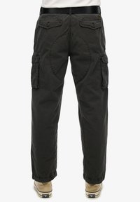 Cargo-broek in donkergrijs met achterzakken, elastische manchetten en een afgeronde naaddetail aan de achterkant. Gemaakt van een duurzame stof.