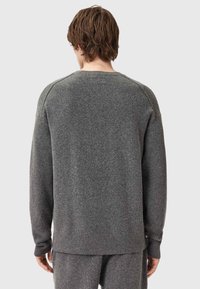 Grauer Pullover aus weichem, strukturiertem Stoff. Pullover-Design mit langen Ärmeln, gerippten Bündchen und Saum. Sauberes, minimalistisches Aussehen.