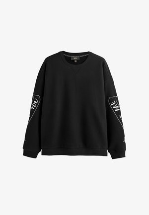 Czarna bluza z długim rękawem i okrągłym dekoltem, z białymi nadrukami tekstowymi na obu rękawach, ściągaczami na rękawach i u dołu, przedstawiona na białym tle.