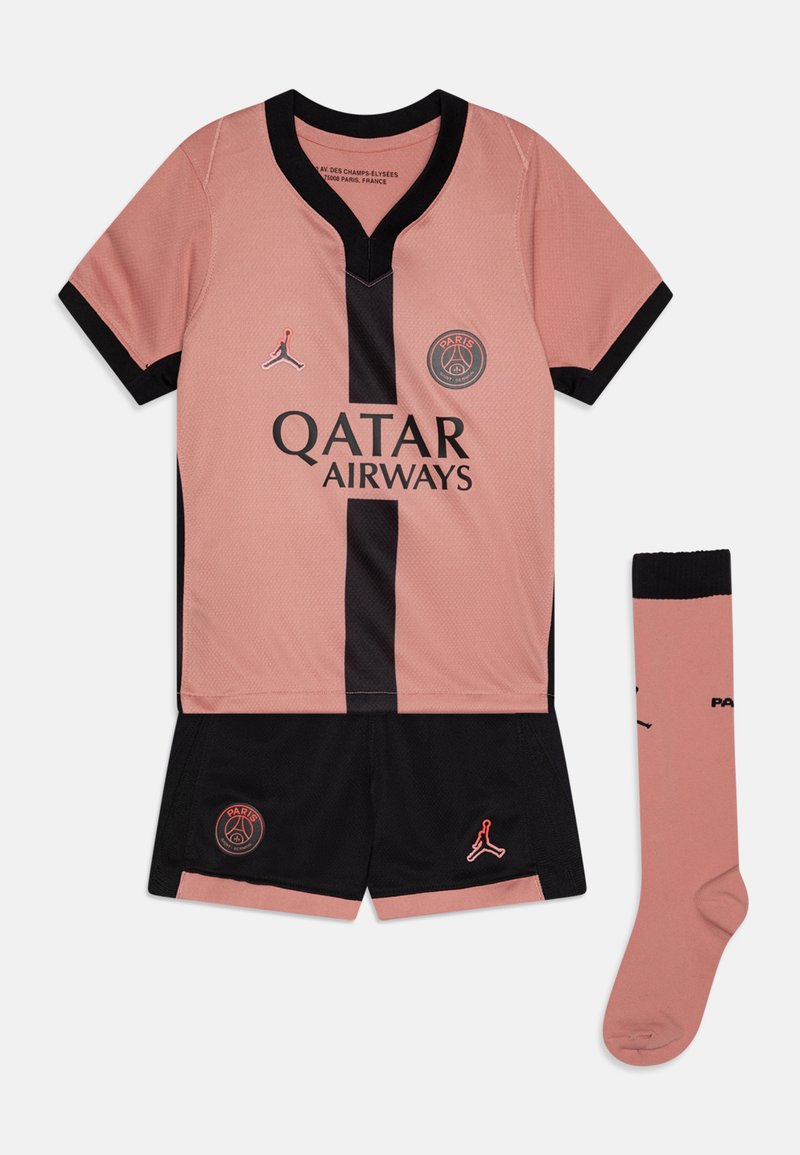 Equipación de fútbol rosa con detalles en negro, camiseta de manga corta, pantalones cortos negros y calcetines a juego. Incluye diseños de logotipos y un collar en forma de V.