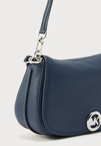 Borsa a tracolla in pelle blu scuro con texture, chiusura a scatto argentata e logo MK, dotata di tracolla staccabile con componenti metalliche argentate.