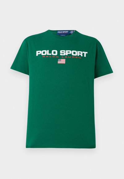 T-shirt de algodão verde com a inscrição "POLO SPORT" e "RALPH LAUREN" em branco e vermelho, acompanhada de um pequeno gráfico da bandeira americana abaixo. Manga curta.