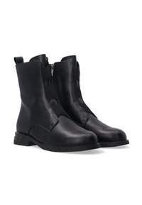 Schwarze Ankle Boots aus Leder mit einer glatten Textur, ausgestattet mit einem asymmetrischen Reißverschluss, elastischen Akzenten und einem niedrigen Blockabsatz.