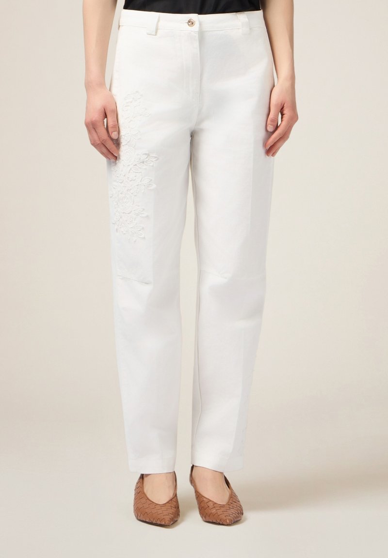 Witte katoenen broek met bloemembroiderie op de linkerdij. De broek heeft een rechte pijpdesign en een knoopsluiting bij de taille.