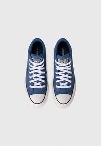 Plave platnene tenisice s bijelim gumiranim potplatima i vezicama, sa zaštitnim vrhom i oznakom "CONVERSE ALL STAR" na jeziku.