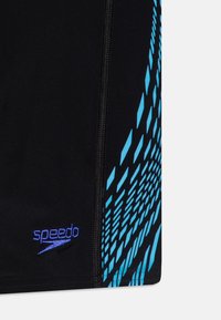 Crne kupaće hlače s plavim uzorkom dijamantnih oblika i bočnim zatvaračem. Speedo logo je izvezen svijetloplavom bojom.