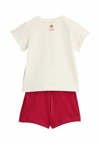 Biela tričko s krátkym rukávom s logami Marvel a Adidas na zadnej strane, spárované s červenými šortkami.