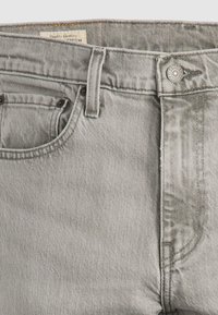 Jeans din denim gri cu un finisaj ușor texturat, design cu cinci buzunare și închidere cu buton metalic. Prezintă o etichetă cusută pe talie.