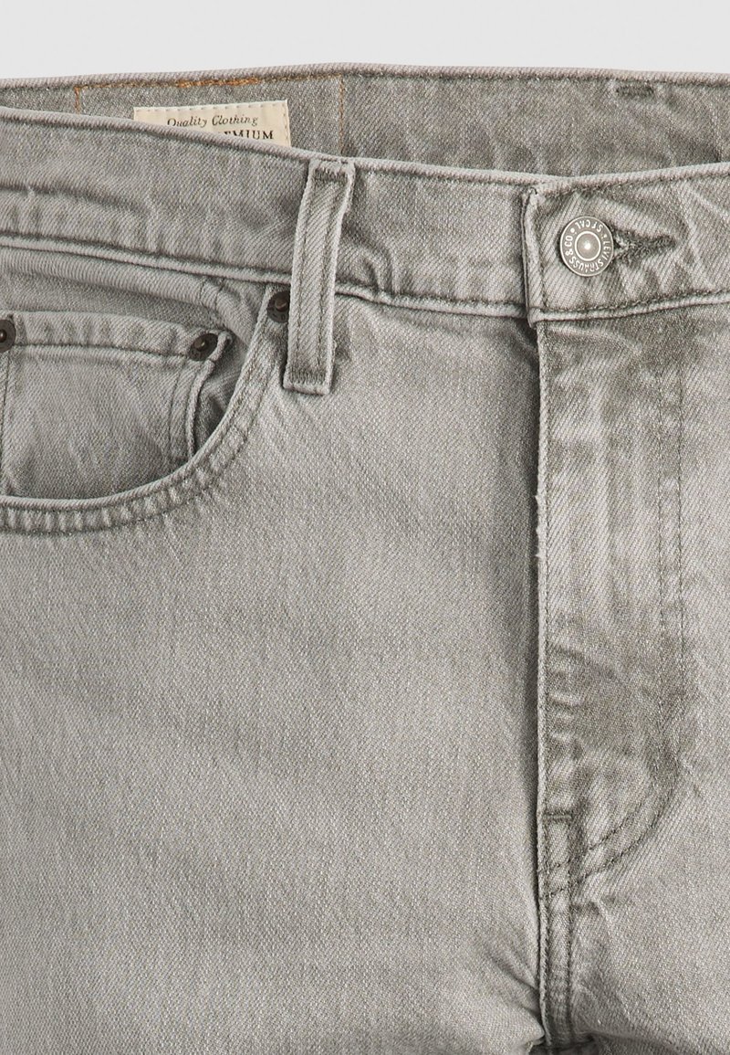 Grijze spijkerbroek van denim met een licht gestructureerde afwerking, vijfzakkenontwerp en metalen knopen sluiting. Voorzien van een gestikte taillebandlabel.