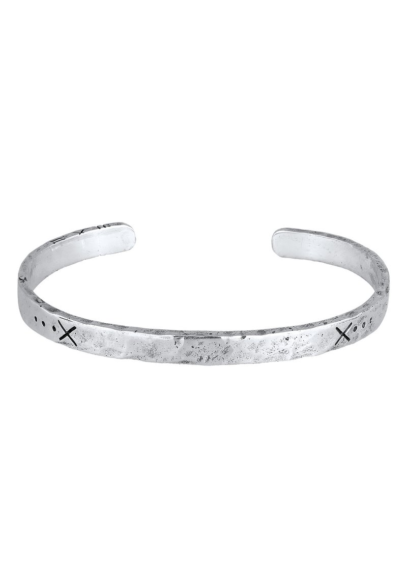 Silverfärgad manschettarmband med en texturerad yta, med ingraverade prickar och kors längs bandet, öppen design i båda ändar.