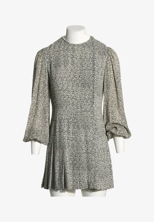 Robe grise à manches longues avec un motif tacheté noir, encolure ronde et manches volumineuses froncées aux poignets sur un mannequin sans tête.