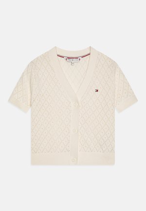 Kremfarget kortermet strikket cardigan med diamantmønster, V-hals og fire knapper foran; har en liten logo nær brystet.