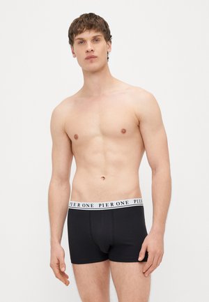 Cuecas boxer pretas com uma cintura branca rotulada "PIER ONE." Design justo ao corpo, textura lisa e sem padrões ou detalhes adicionais.