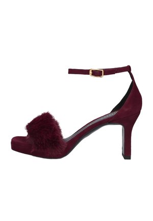 Bordeauxrode suède sandalen met hoge hak, enkelbandje en gouden gesp, met een pluizige bontband aan de voorkant.